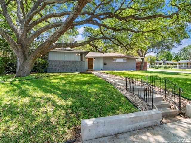 ranch-style house with a front yard and brick siding