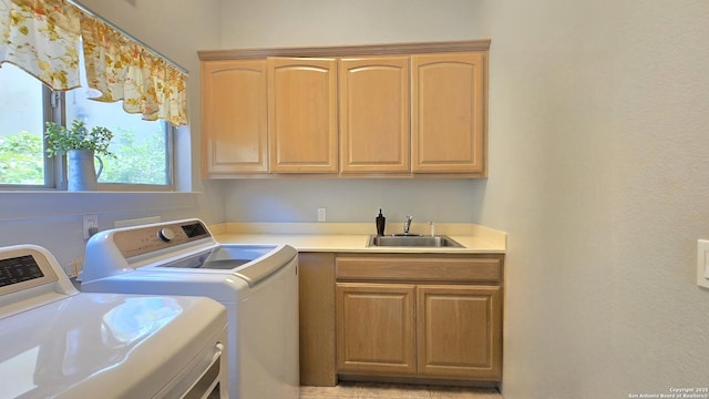 clothes washing area with washer and dryer, indoor wet bar, a sink, and cabinet space