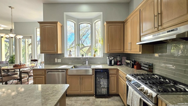 kitchen featuring backsplash, under cabinet range hood, stainless steel appliances, beverage cooler, and a sink