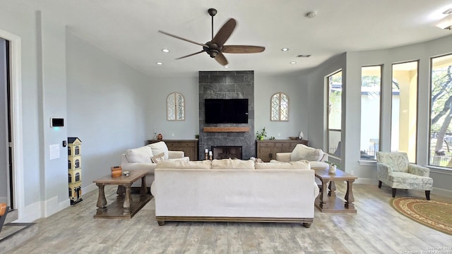 living room featuring a large fireplace, recessed lighting, visible vents, ceiling fan, and light wood finished floors
