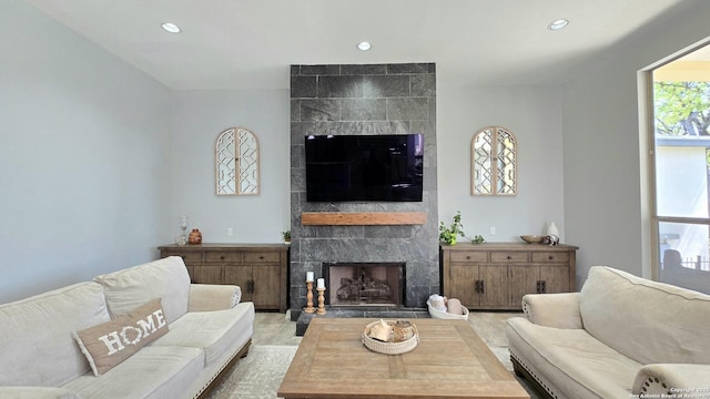 living area with recessed lighting and a tiled fireplace