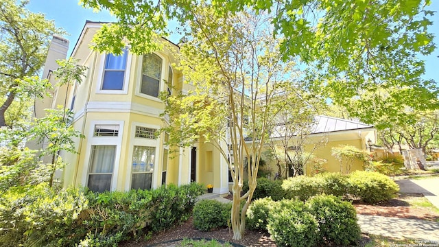 view of front of property featuring a chimney and stucco siding