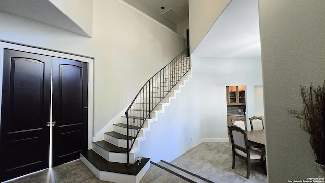 stairway featuring a high ceiling and wood finished floors