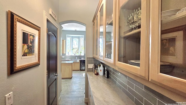 interior space with arched walkways, a sink, and wine cooler