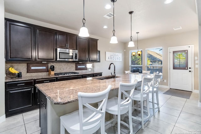 500 Pecan Farms, New Braunfels, TX 78130 - kitchen with visible vents, a sink, stainless steel microwave, decorative backsplash, and gas cooktop