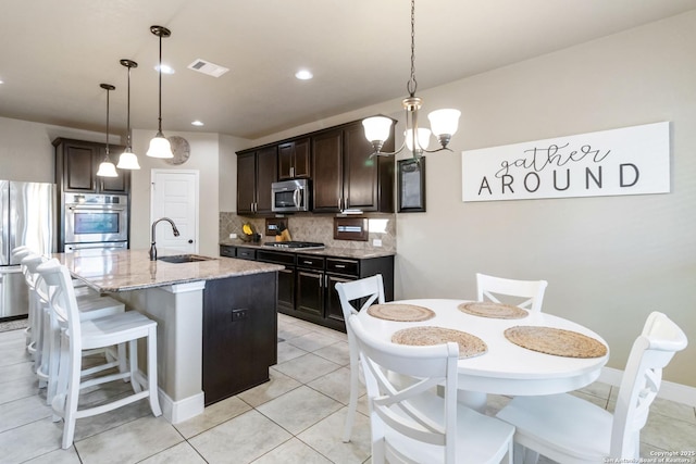 500 Pecan Farms, New Braunfels, TX 78130 - kitchen with appliances with stainless steel finishes, light stone countertops, visible vents, decorative backsplash, and a sink