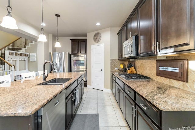 500 Pecan Farms, New Braunfels, TX 78130 - kitchen featuring dark brown cabinetry, appliances with stainless steel finishes, light stone counters, a sink, and backsplash