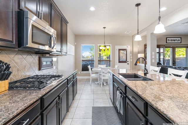 500 Pecan Farms, New Braunfels, TX 78130 - kitchen with baseboards, backsplash, light stone countertops, appliances with stainless steel finishes, and a sink