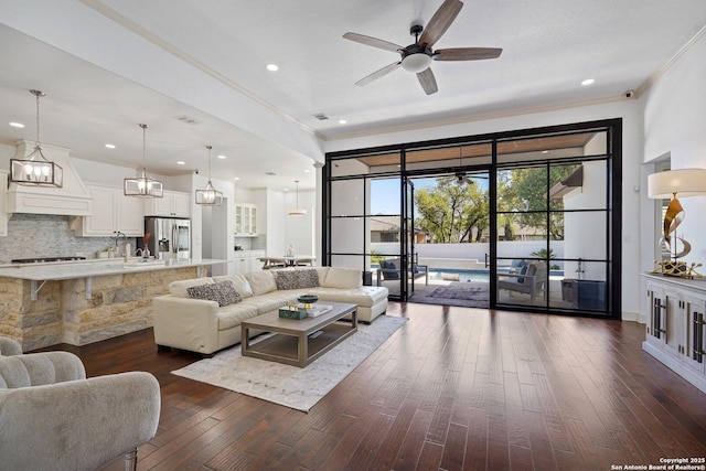 living area featuring crown molding, ceiling fan, dark wood-type flooring, visible vents, and recessed lighting