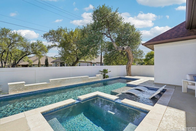 view of pool featuring a fenced backyard, a pool with connected hot tub, and a patio area