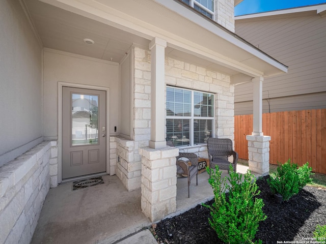 6810 Courante Waltz, San Antonio, TX 78252 - property entrance featuring fence, stone siding, and covered porch