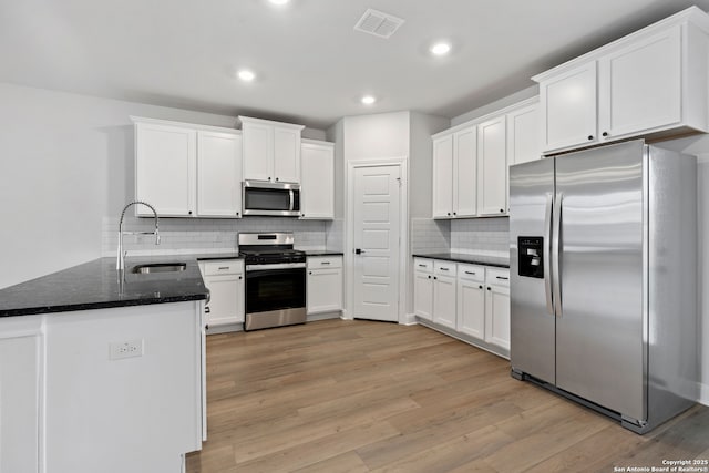 9622 Nubuck Br, Converse, TX 78109 - kitchen featuring light wood-type flooring, white cabinets, visible vents, appliances with stainless steel finishes, and a sink