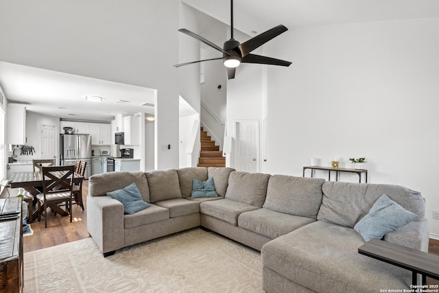9311 Longmire, San Antonio, TX 78245 - living room with a high ceiling, light wood-style floors, ceiling fan, and stairway