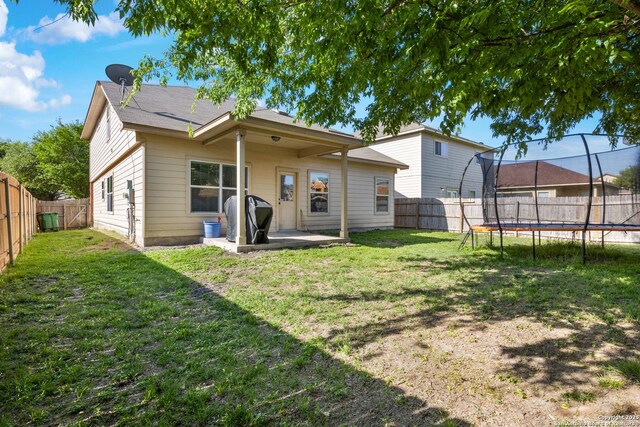 9311 Longmire, San Antonio, TX 78245 - rear view of property featuring a trampoline and a patio area