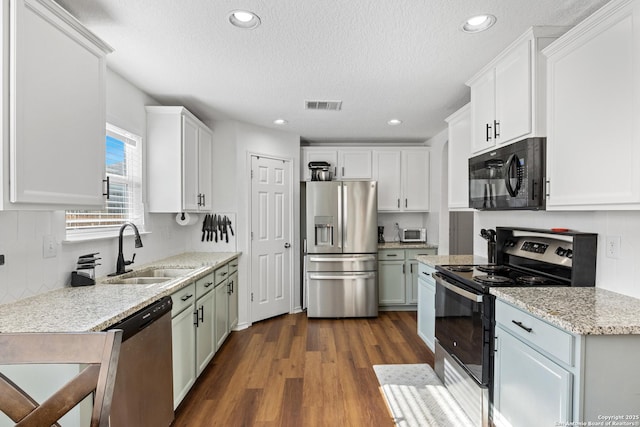 9311 Longmire, San Antonio, TX 78245 - kitchen featuring stainless steel appliances, a sink, a textured ceiling, dark wood-type flooring, and recessed lighting