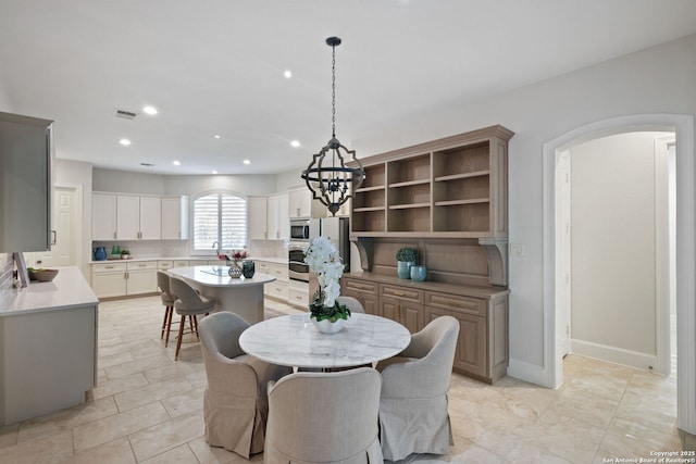 dining room with visible vents, arched walkways, light tile patterned floors, a notable chandelier, and recessed lighting