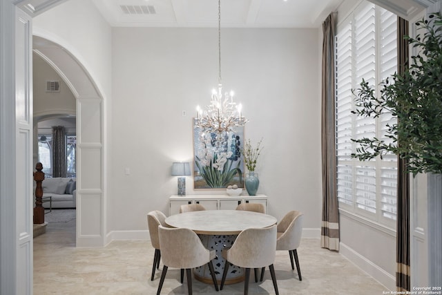 dining area featuring an inviting chandelier, arched walkways, plenty of natural light, and visible vents