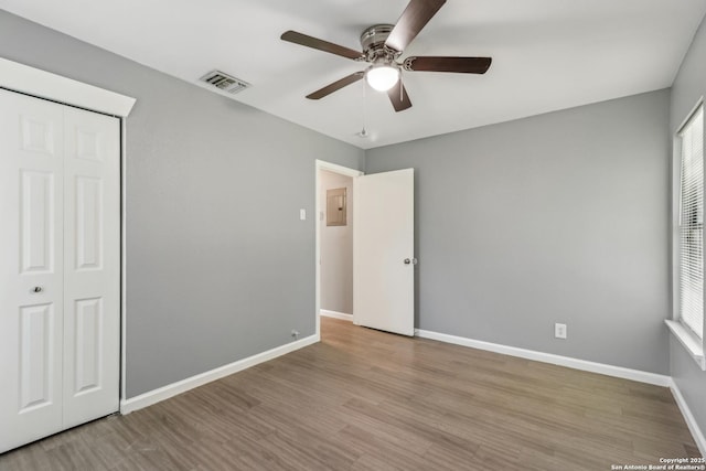 2415 Spicewood, San Antonio, TX 78213 - unfurnished bedroom featuring wood finished floors, electric panel, a closet, baseboards, and ceiling fan