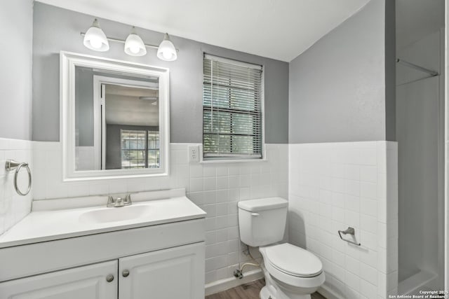 2415 Spicewood, San Antonio, TX 78213 - bathroom featuring toilet, tile walls, a wainscoted wall, vanity, and wood finished floors