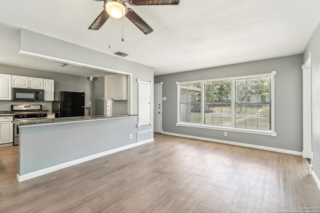 2415 Spicewood, San Antonio, TX 78213 - kitchen with black appliances, wood finished floors, white cabinetry, and baseboards