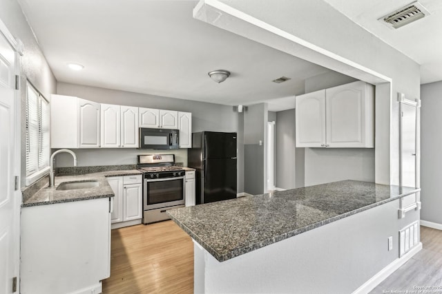 2415 Spicewood, San Antonio, TX 78213 - kitchen with black appliances, a sink, a peninsula, light wood-type flooring, and white cabinetry