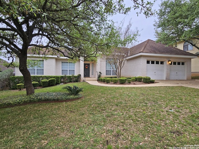 ranch-style house with an attached garage, driveway, a tiled roof, and a front lawn