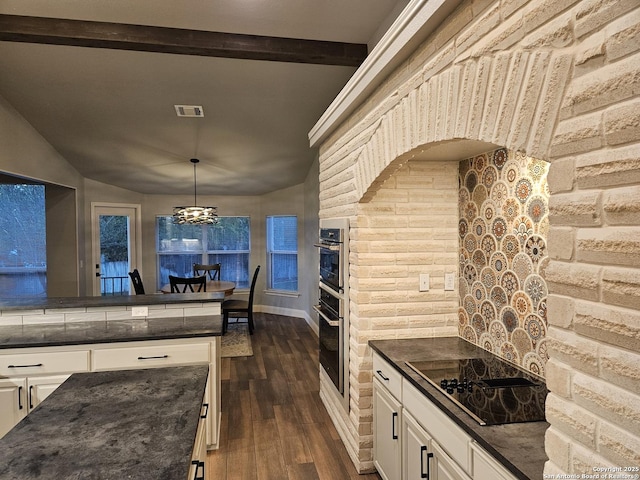 kitchen featuring dark wood-style floors, dark countertops, white cabinets, visible vents, and black electric cooktop