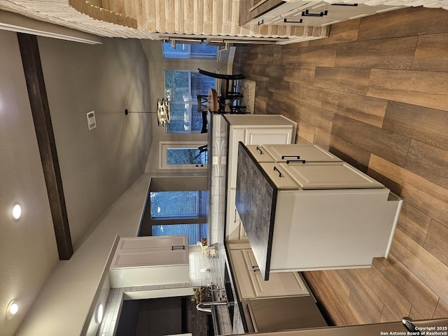 kitchen with wood finished floors and wooden walls