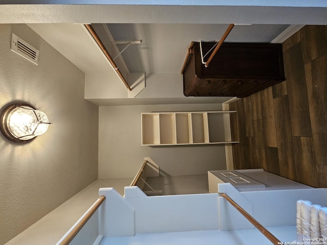stairway featuring visible vents and a textured wall