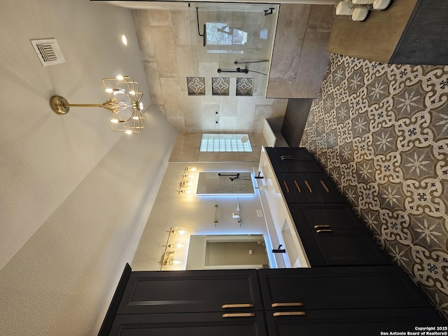kitchen with visible vents, dark cabinetry, and stovetop