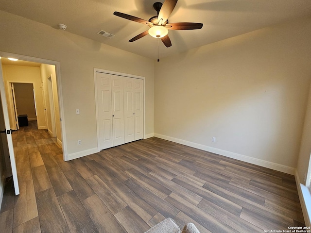 unfurnished bedroom with visible vents, baseboards, a closet, a ceiling fan, and dark wood finished floors