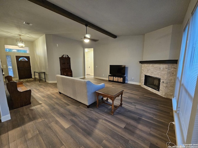 living area with a fireplace, dark wood-style floors, baseboards, and beamed ceiling