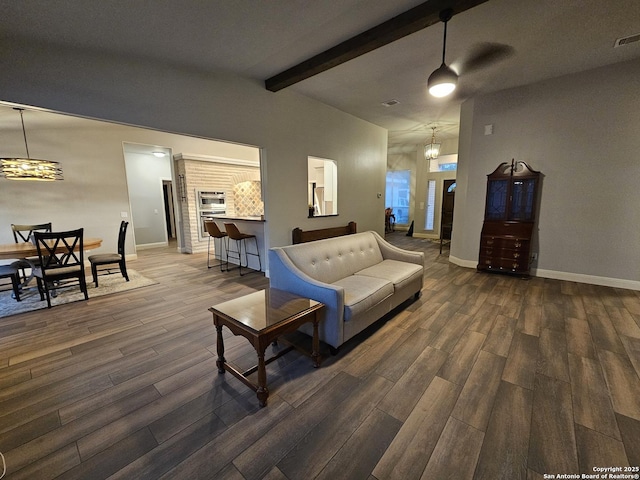 living room featuring wood finished floors, a notable chandelier, vaulted ceiling with beams, and baseboards