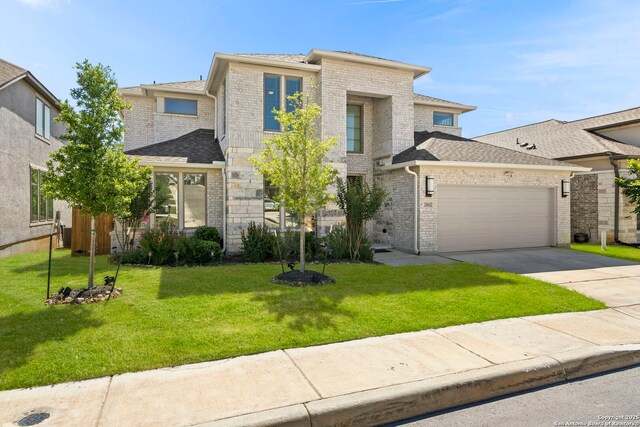 view of front of home featuring an attached garage, brick siding, driveway, and a front yard