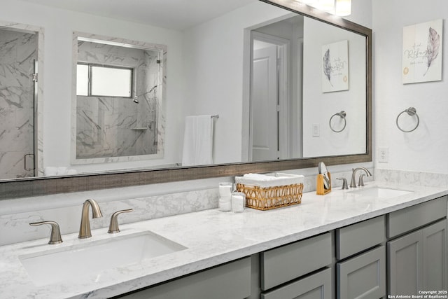 full bathroom with double vanity, a marble finish shower, and a sink