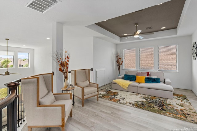 living area featuring a ceiling fan, wood finished floors, visible vents, and recessed lighting