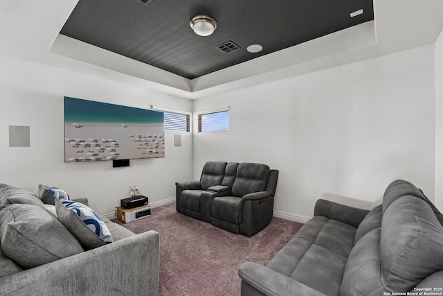 living room with a raised ceiling, visible vents, carpet flooring, and baseboards