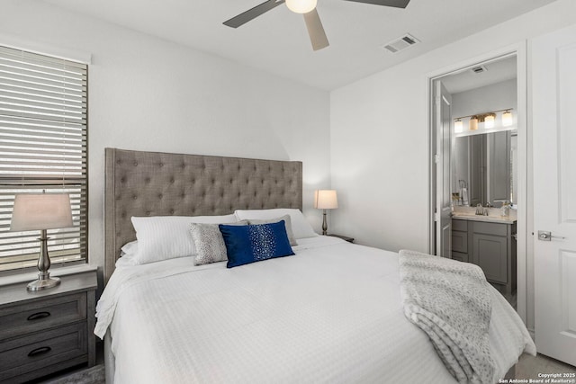 bedroom with ensuite bath, visible vents, a ceiling fan, and a sink
