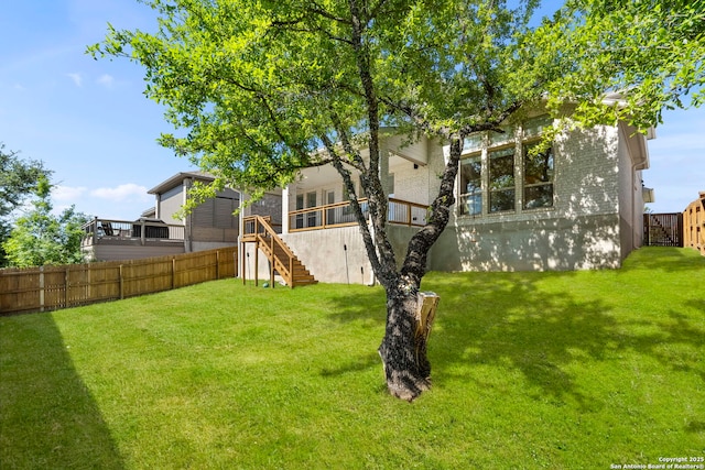view of yard featuring a fenced backyard, a wooden deck, and stairway