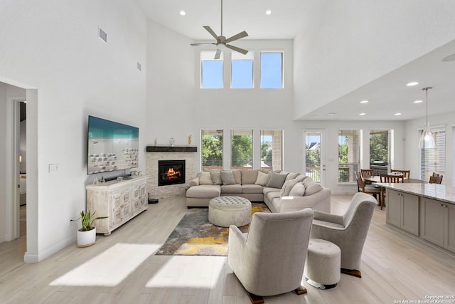 living area featuring ceiling fan, a towering ceiling, and plenty of natural light