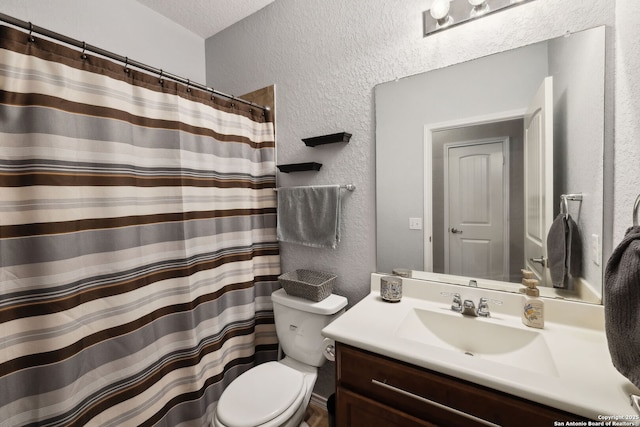 full bathroom with a textured wall, a shower with shower curtain, vanity, and toilet