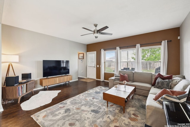living area featuring baseboards, a ceiling fan, and wood finished floors