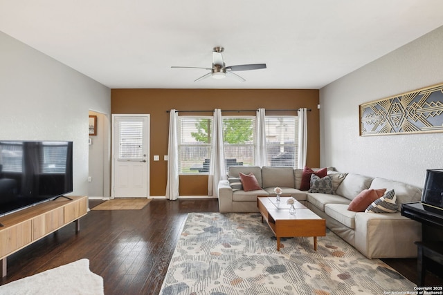 living room featuring baseboards, a ceiling fan, and hardwood / wood-style floors