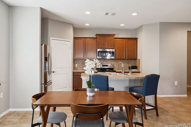 kitchen with decorative backsplash, light countertops, a sink, and appliances with stainless steel finishes