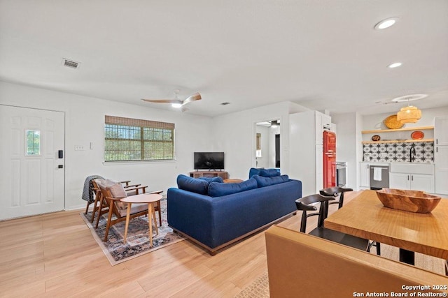 living room with a ceiling fan, recessed lighting, and light wood finished floors