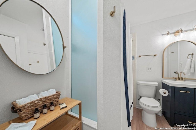 bathroom with vanity, toilet, and wood finished floors