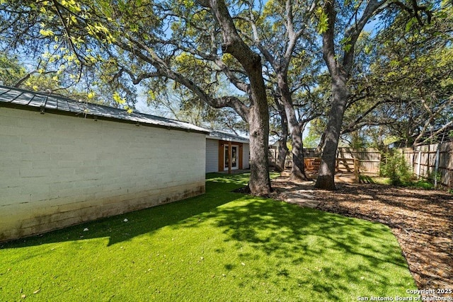 view of yard featuring french doors and fence