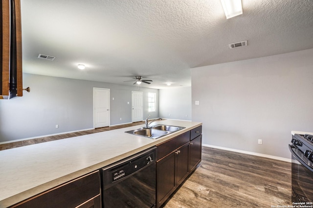 kitchen with visible vents, a sink, light countertops, dark wood finished floors, and black appliances