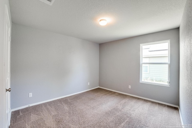 empty room featuring carpet flooring, a textured ceiling, and baseboards