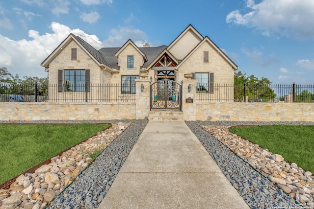 view of front of home featuring stone siding, a gate, and a fenced front yard